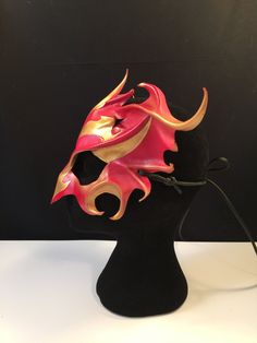 DESCRIPTIONRise from the ashes and transform anew wearing this gorgeous red & gold leather Phoenix Mask. This firebird piece is perfect for Carnivale or Bird CosPlay! Quality leather bird mask, fantastic for Carnivale or Mardi Gras costume. Any color. Waterproofed leather, glossy or matte finish, & several choices to affix the mask (cord, elastic, ribbon, waterproof cord). Measurements: 10" high x 14" wide (tallest & widest points); 10" high between the eyes; 3" wide x 1.5" tall eye openings. -- Phoenix Mask, Bird Cosplay, Mask Cord, New Years Eve Ball, Bird Mask, Bird Costume, Bird Masks, Mardi Gras Costumes, Elastic Ribbon