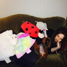 a woman sitting on a couch with stuffed animals