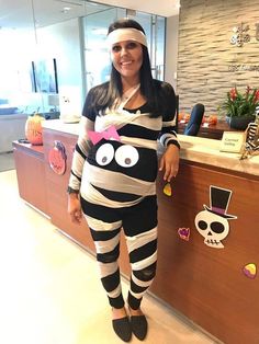 a woman dressed up as a zebra standing in front of a counter with decorations on it