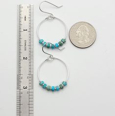 Add a pop of color to your boho look with our silver hoop earrings featuring turquoise jasper stones. These playful and unique earrings will bring a touch of whimsy to any outfit. .925 Sterling Silver Measure approximately 1.125" in diameter Earrings Hang 1.75" from top of ear wire Turquoise Jasper Gemstones Polished to a high shine Sent in a Gift Box with Polishing Cloth Handmade in Montana Turquoise Hoop Earrings With Natural Stones, Minimalist Turquoise Hypoallergenic Hoop Earrings, Minimalist Hypoallergenic Turquoise Hoop Earrings, Everyday Nickel-free Turquoise Jewelry, Turquoise Dangle Hoop Earrings Wire Wrapped, Bohemian Turquoise Hoop Earrings Nickel Free, Turquoise Wire Wrapped Dangle Hoop Earrings, Turquoise Natural Stone Hoop Earrings As Gift, Turquoise Hoop Earrings With Natural Stones As Gift