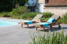 two chaise lounge chairs next to a swimming pool