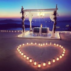 a heart made out of lit candles on top of a table in the shape of a heart