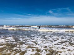 two people in the ocean with surfboards