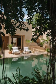 an outdoor swimming pool with lounge chairs and steps leading up to the house's entrance