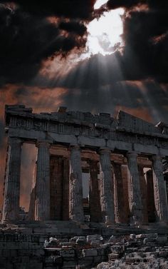 the sun shines brightly through clouds over an ancient temple with columns and pillars on it