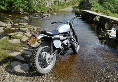 a motorcycle parked on the side of a river