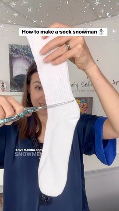 a woman holding up a pair of white socks to her face with the words how to make a sock snowman on it