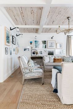 a living room filled with furniture and pictures on the wall