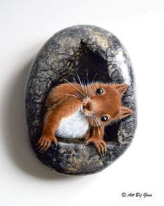 a rock with a painting of a mouse on it's face in the shape of a stone