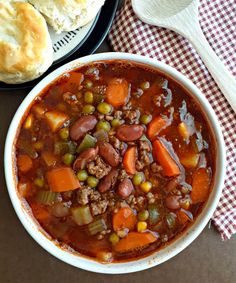 a white bowl filled with soup next to a plate of bread on top of a table