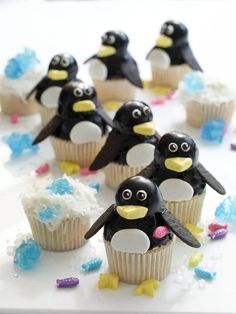 some cupcakes with penguins on them and frosting