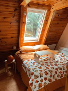 a bed with an orange bedspread in a small room next to a window