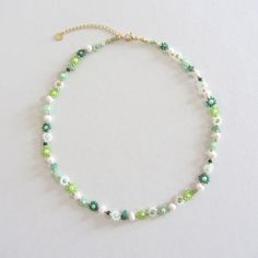 a green and white beaded necklace with pearls