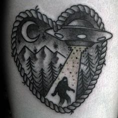 a black and white photo of a heart shaped tattoo with an alien ship on it