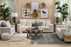 a living room filled with white furniture and lots of greenery on the windowsill