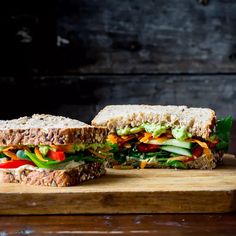 a cut in half sandwich sitting on top of a wooden cutting board