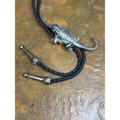 Add a touch of Western style to your outfit with this unique bolo tie. Featuring the beloved, native southwestern horned toad design, this tie is perfect for any cowboy or Western enthusiast. The black color of the tie complements any outfit, and its 37-inch length ensures a comfortable fit.  This bolo tie is a great gift for anyone, whether it's for Dad, Son, or Husband. Its antique design and unknown origin add to its mystery and appeal. Perfect for any occasion, this tie is sure to make a statement. So why wait? Add this HORNED TOAD TX Bolo Tie to your collection today! Horned Toad, Western Gifts, Bolo Ties, Dad Son, Bolo Tie, Wedding Ties, Cow Boy, Mens Neck Ties, Vintage Mickey