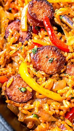 a plate full of rice with sausage and peppers