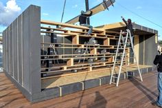 two men are working on the roof of a building that is being built with wood