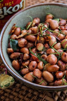 a close up of a bowl of food on a table next to a drink can