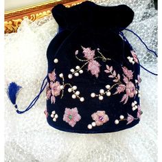 With a simple pull of the tasseled cords, you secure your prized possessions in this beautiful velvet embroidered bucket bag or potli bag embellished with genuine semi precious stones. A welcome feature is a removable chain shoulder strap for hands-free convenience. Perfect for Indian wedding or for fun around town! Expertly hand embroidered by third generation master zardozi artisans. Of exceptional quality. Our aim is the preservation of the zardozi embroidery art form, a centuries-old elabora Beaded Pouch Bag, Essential Fashion Pieces, Bride And Prejudice, Embellished Purses, Chinese Theme, Purse Ideas, Beaded Pouch, Zardozi Embroidery, Potli Bag