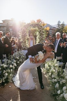 a bride and groom kiss as they walk down the aisle