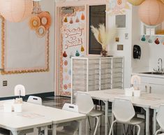 a room with tables, chairs and decorations on the wall in front of a door