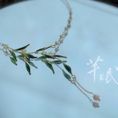 a necklace with green leaves and pearls on a white background, written in chinese characters