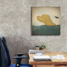 an office with a blue chair and a painting on the wall above it that has a dog floating in the water