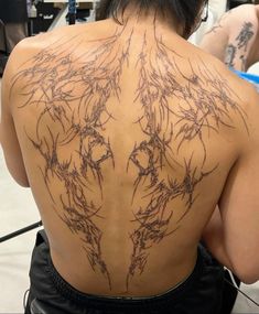 the back of a woman with tattoos on her back