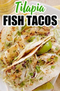 fish tacos on a white plate with limes and cilantro in the background