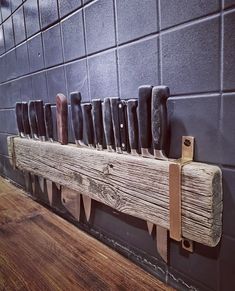 a bunch of knives are hanging on a wall