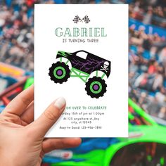 a person holding up a card with a monster truck on it