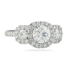 an engagement ring with three stone halos and round brilliant cut diamonds on the band