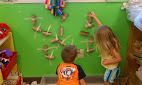 two children are playing with wooden pegs on the wall