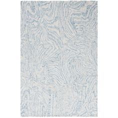 a blue and white rug with an abstract design on the bottom, in front of a white background