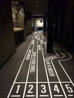 a long hallway with white numbers on the floor