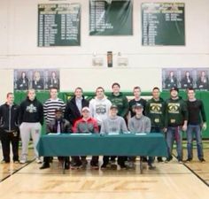 the men's basketball team is posing for a photo in front of a table