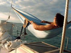 a man laying in a hammock on a boat