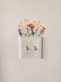 an electrical outlet with flowers painted on it