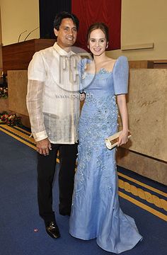 the man and woman are posing for a photo together in formal wear at an event