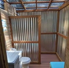 a small bathroom with a toilet, sink and shower stall in the middle of it