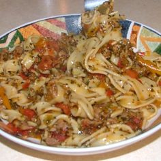 a bowl filled with pasta and meat on top of a table