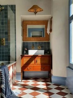 a bathroom with a checkered floor and tiled walls, along with a wooden vanity