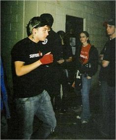 a group of young men standing next to each other in front of a door with gloves on