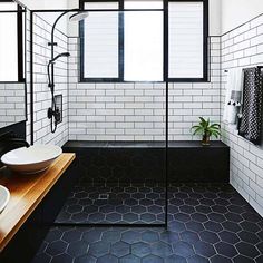 a bathroom with black and white tiles on the walls