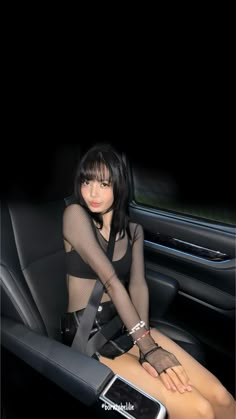 a woman sitting in the back seat of a car wearing fishnet stockings and garters