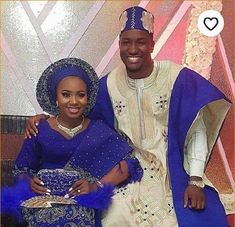 a man and woman dressed in traditional african garb posing for a photo while holding a bowl