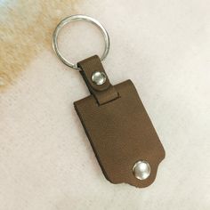 a brown leather keychain with two metal balls on it