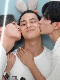 three young men kissing each other in front of a mirror